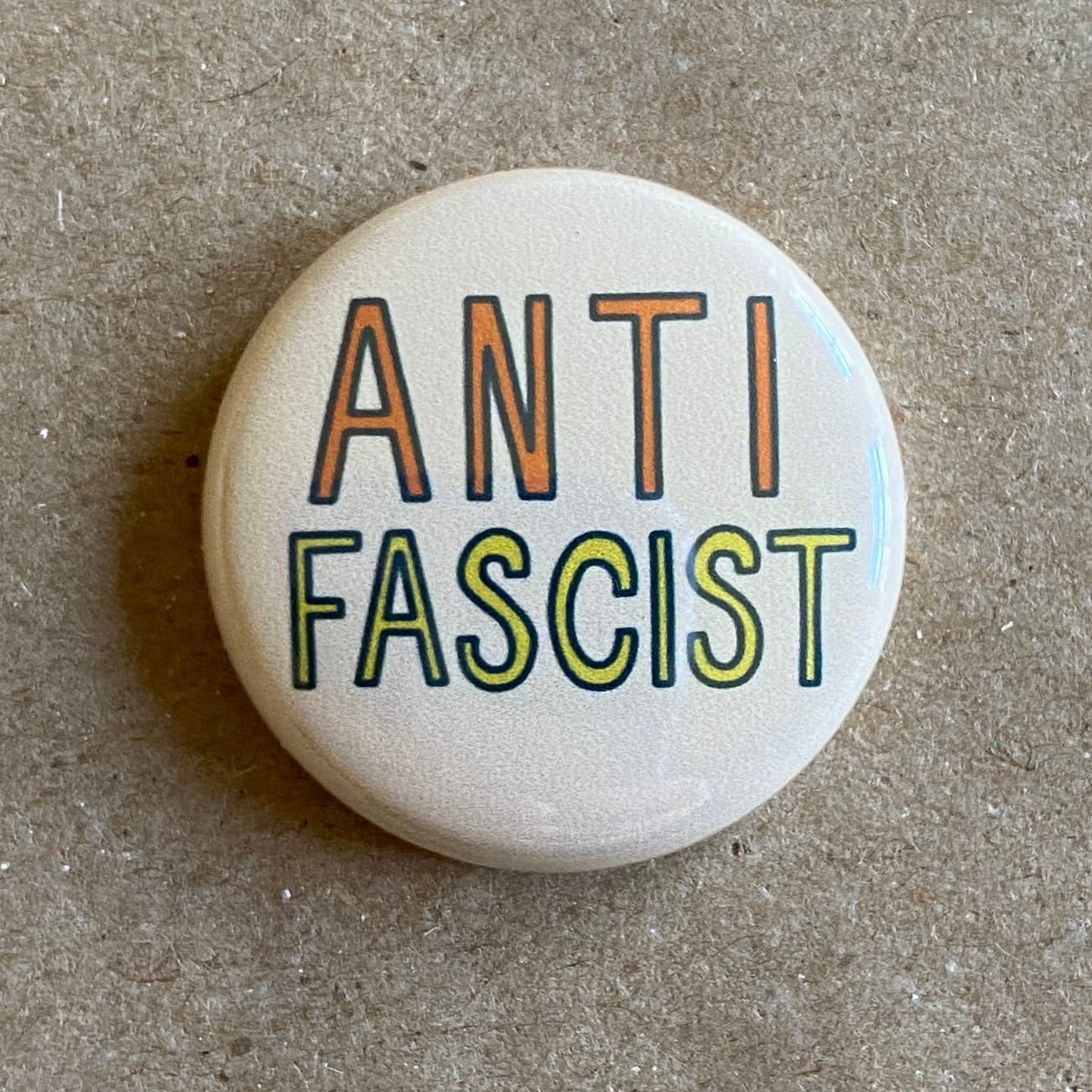 a pin back button with original hand lettering by AnneArchy, of "anti-fascist"