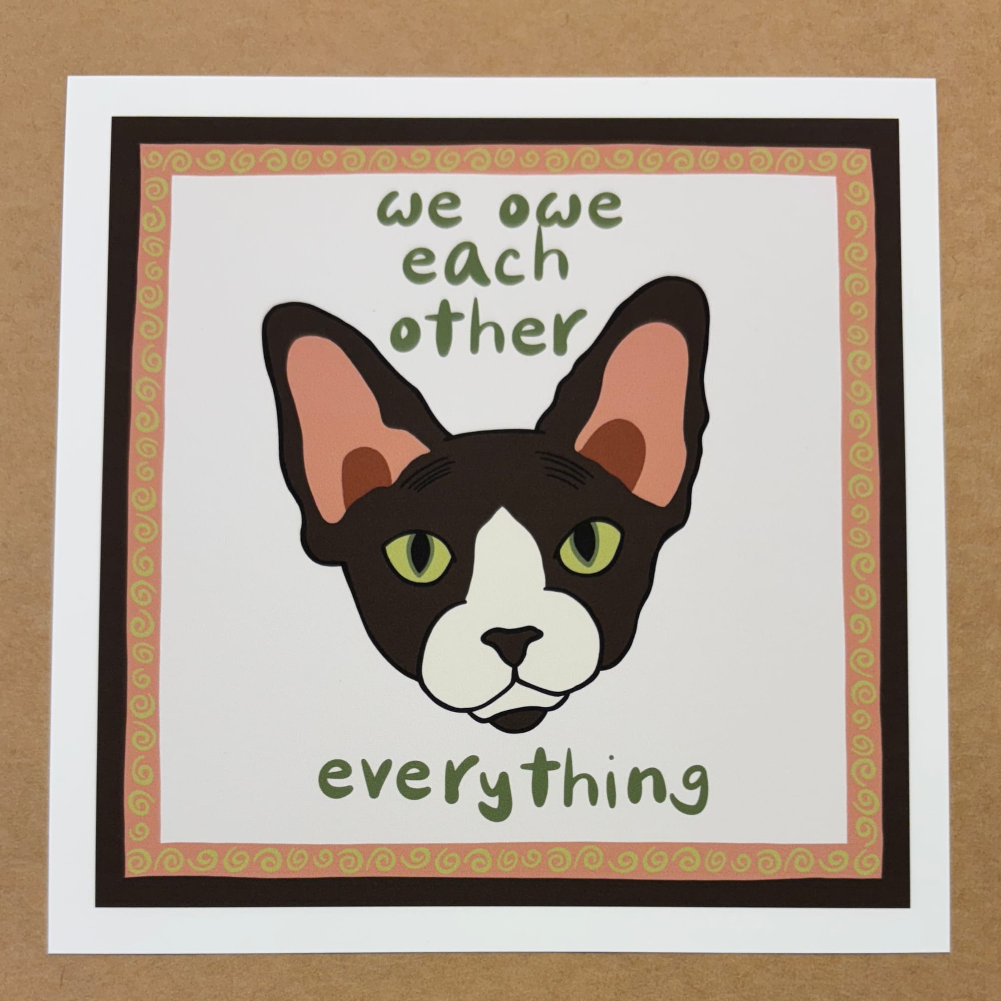 original art by AnneArchy of a sphynx cat's head with hand lettering of the words "we owe each other everything." 