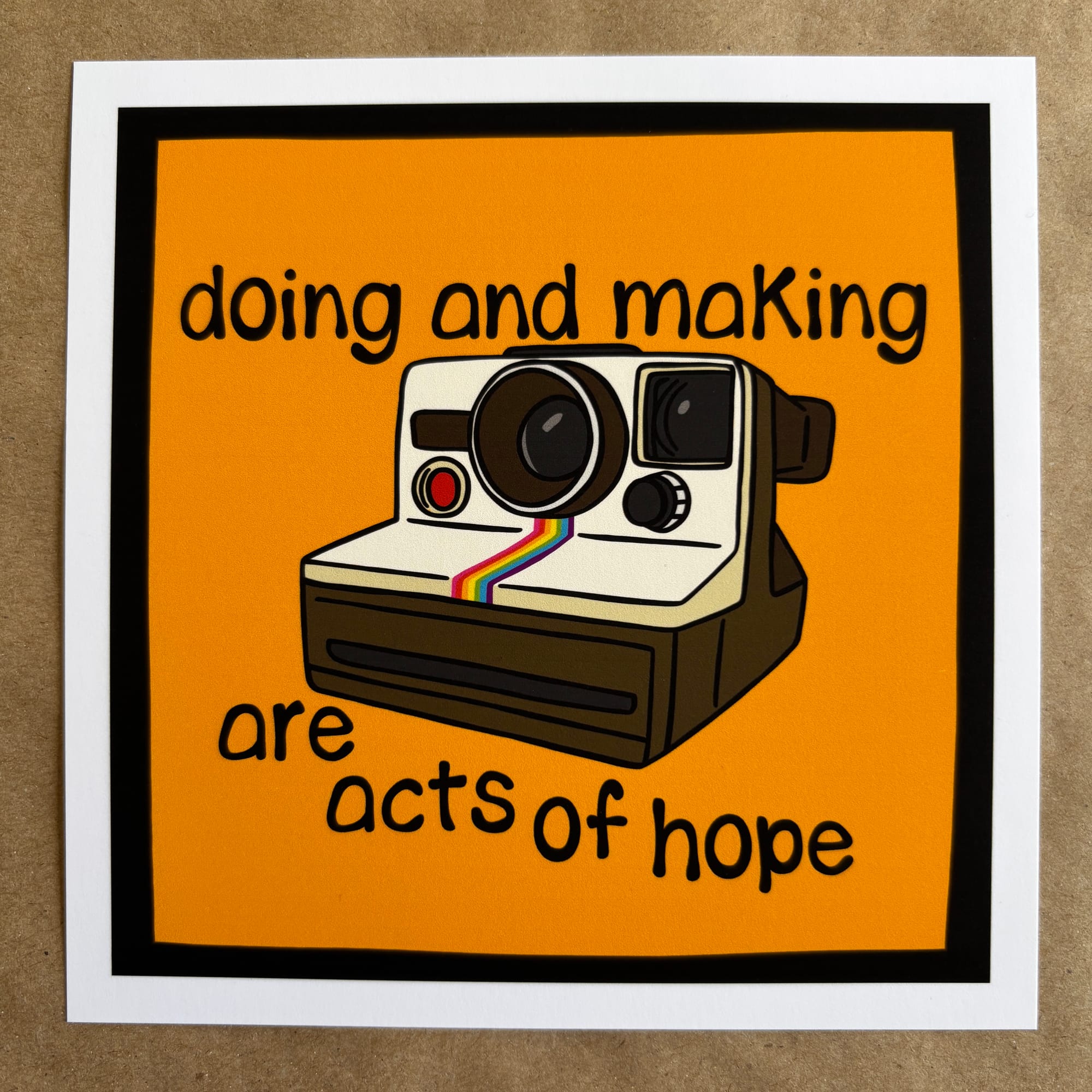 original art by AnneArchy depicting a vintage polaroid camera with hand lettering of the words "doing and making are acts of hope"