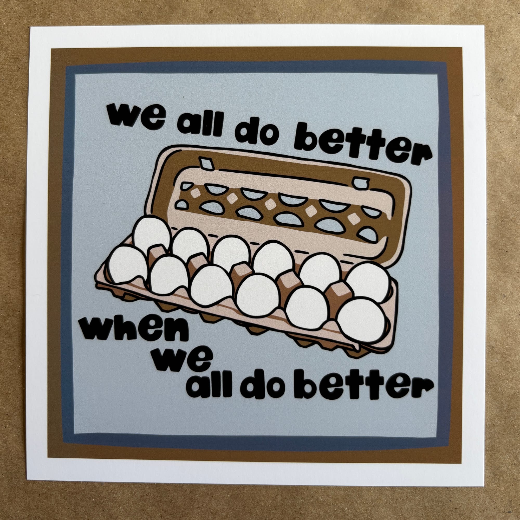 original art by AnneArchy depicting a carton of eggs with hand lettering of the words "we all do better when we all do better"
