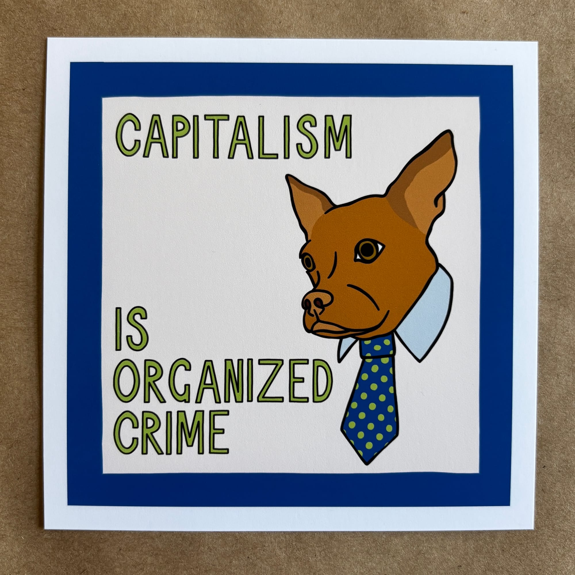 original art by AnneArchy depicting a cinnamon dog wearing a collar and neck tie with hand lettering of the words "capitalism is organized crime"