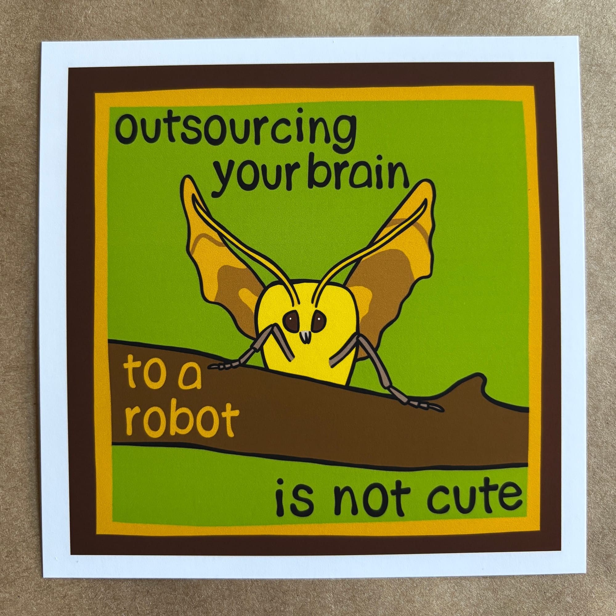 original art by AnneArchy depicting a yellow moth and hand lettering of the words "outsourcing your brain to a robot is not cute"