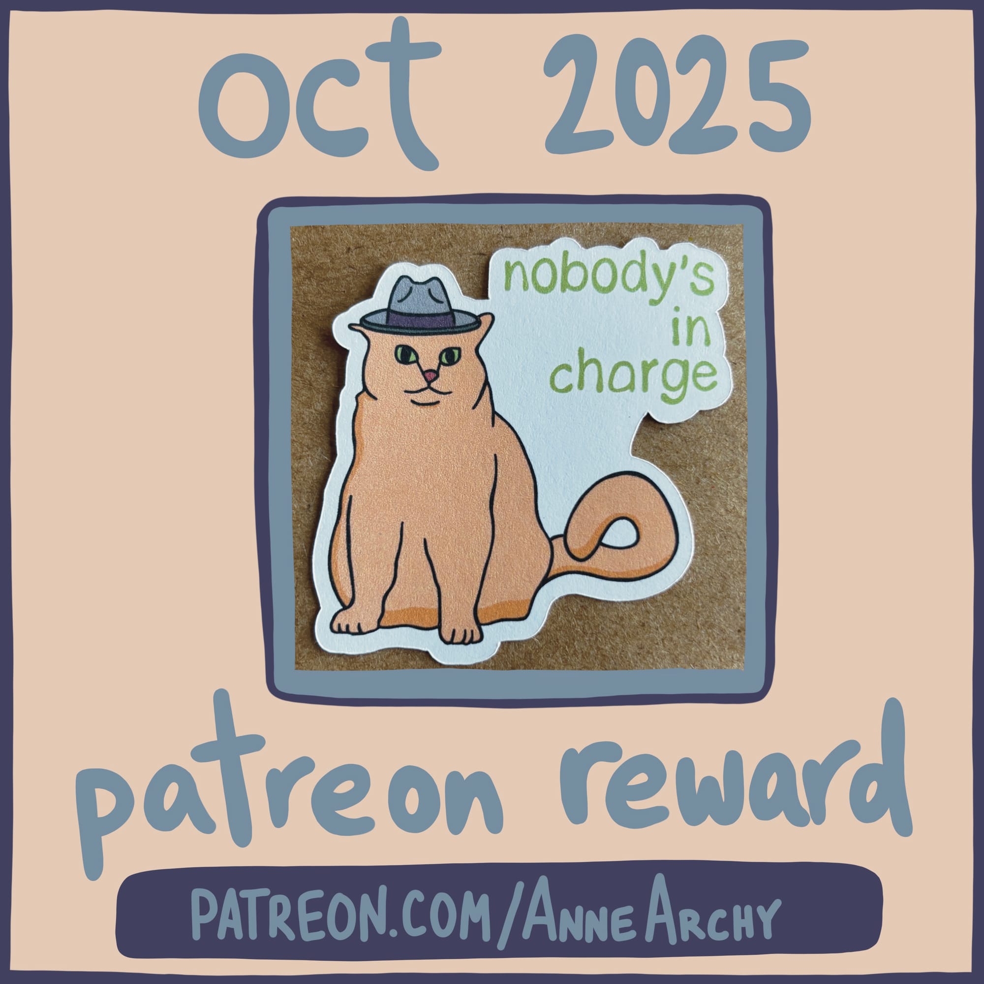 promotional image for AnneArchy October 2025 patreon, featuring a photo of an original art sticker depicting an orange cat wearing a grey hat with hand lettering of the words "nobody's in charge"