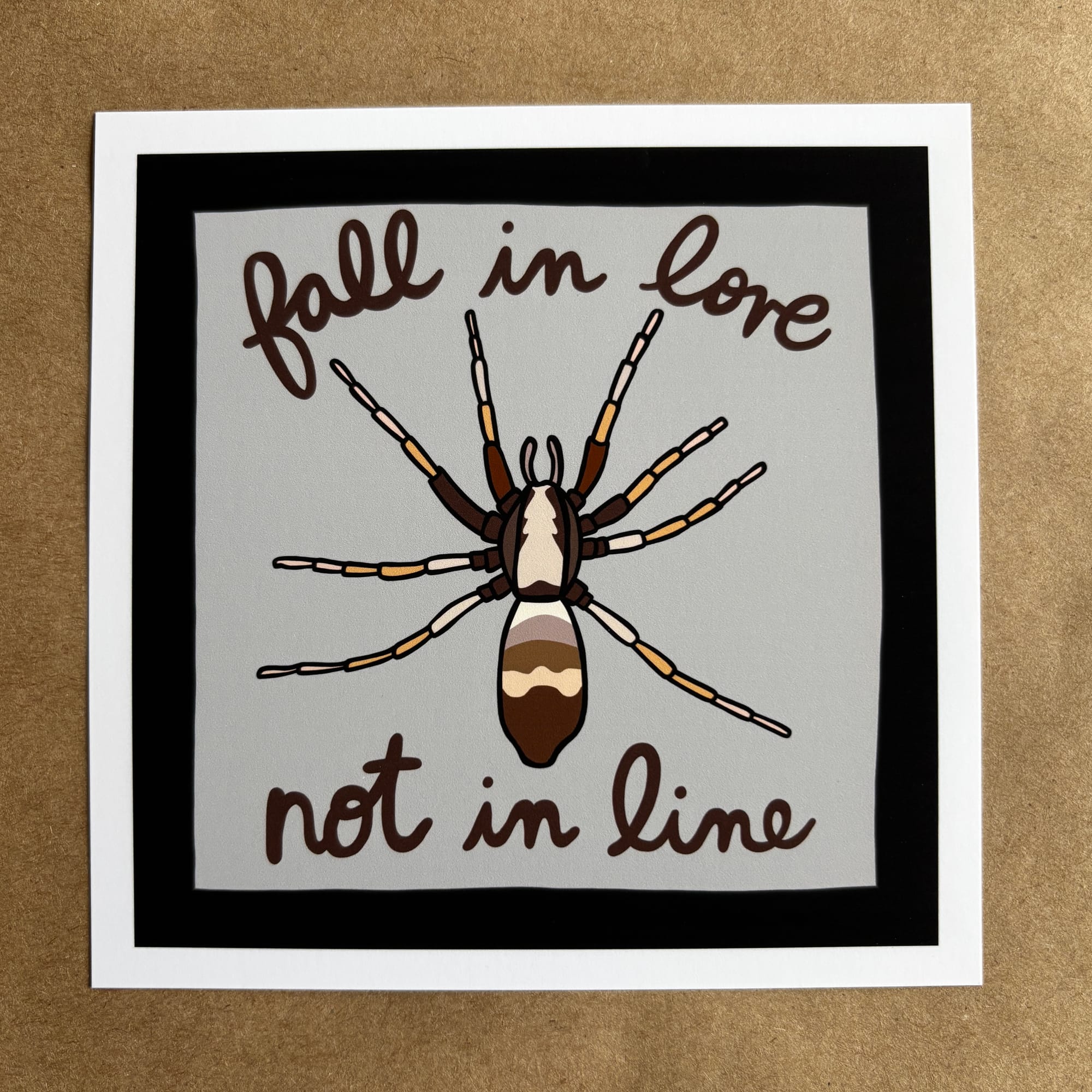 original art by AnneArchy depicting a spider with hand lettering of the words "fall in love not in line"