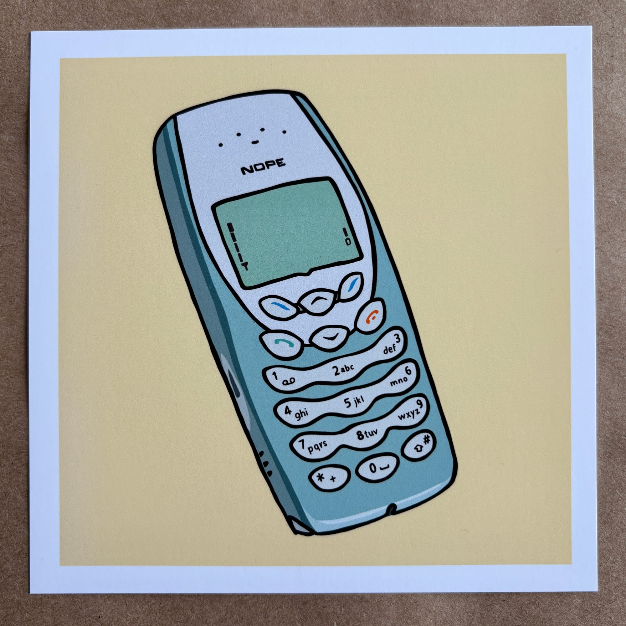original art by AnneArchy of a classic early aughts Nokia phone with hand lettering of the word "nope" on it. 