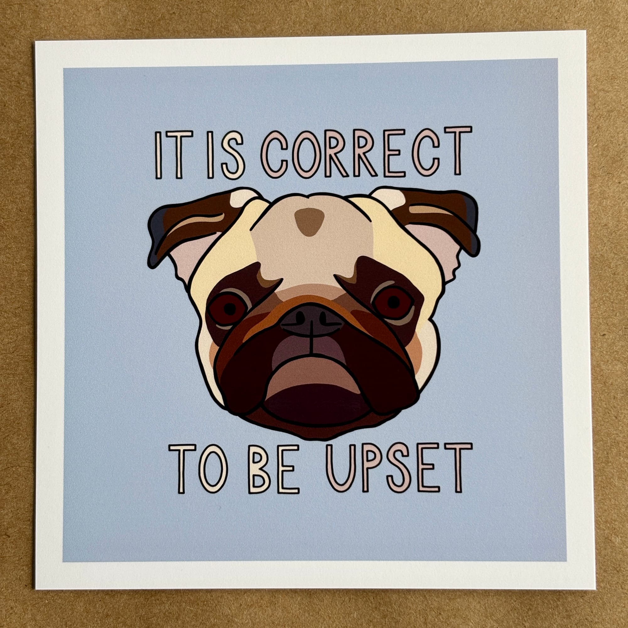 Original art by AnneArchy of a pug’s face with hand-lettering of the words "it is correct to be upset."